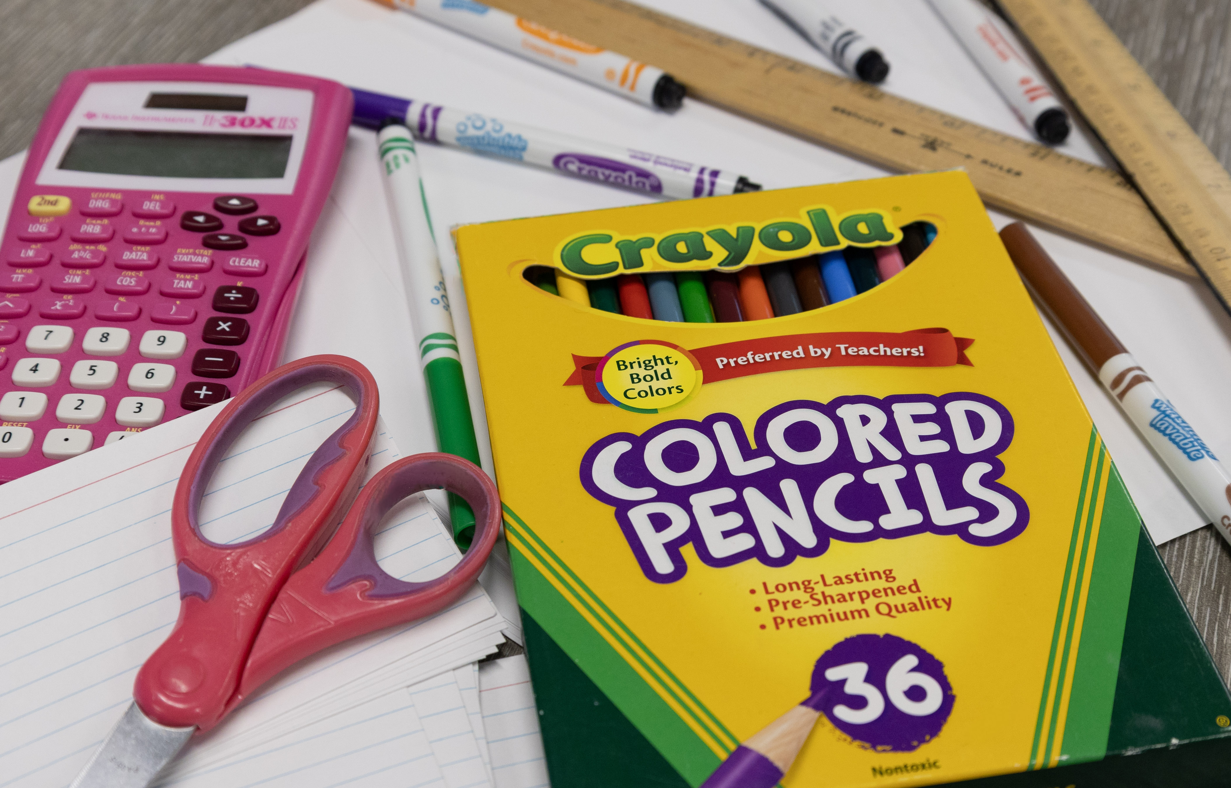 Paper, pencils, scissors, and other school supplies set for a picture