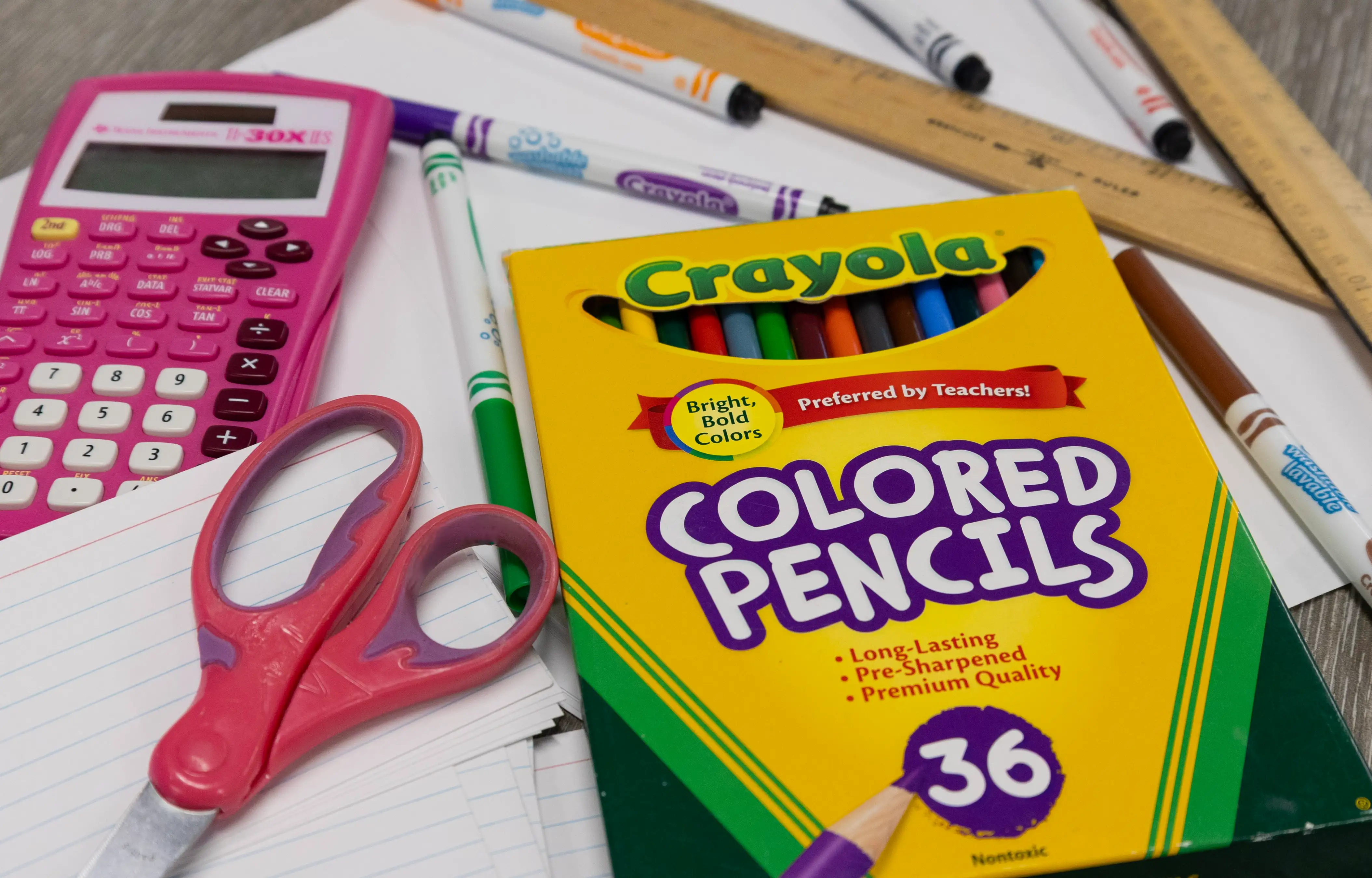 Paper, pencils, scissors, and other school supplies set for a picture